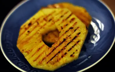 Tranches d'ananas grillées sur une assiette bleue.