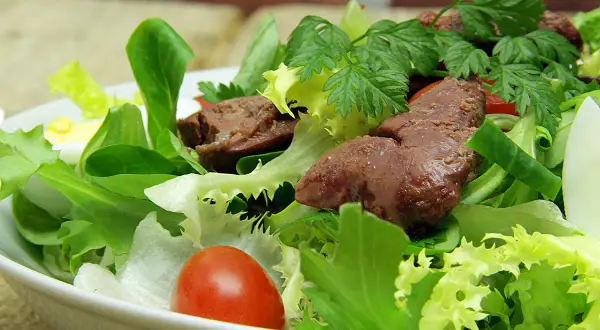 Salade de foies de volaille avec laitue, tomates cerises, œuf dur et persil.