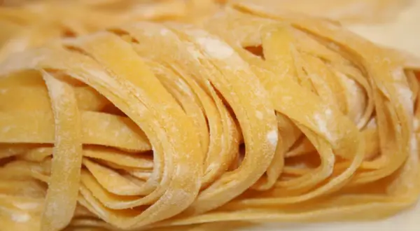 Pâtes fraîches aux œufs, enroulées en nid, saupoudrées de farine.