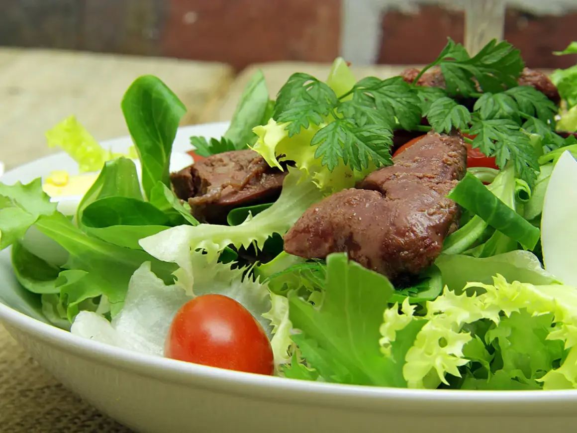 Salade de foies de volaille avec laitue, tomates cerises, œuf dur et persil.