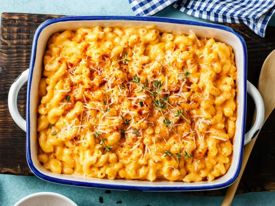 Gratin de pâtes crémeux et doré, garni de fromage râpé et de thym frais.